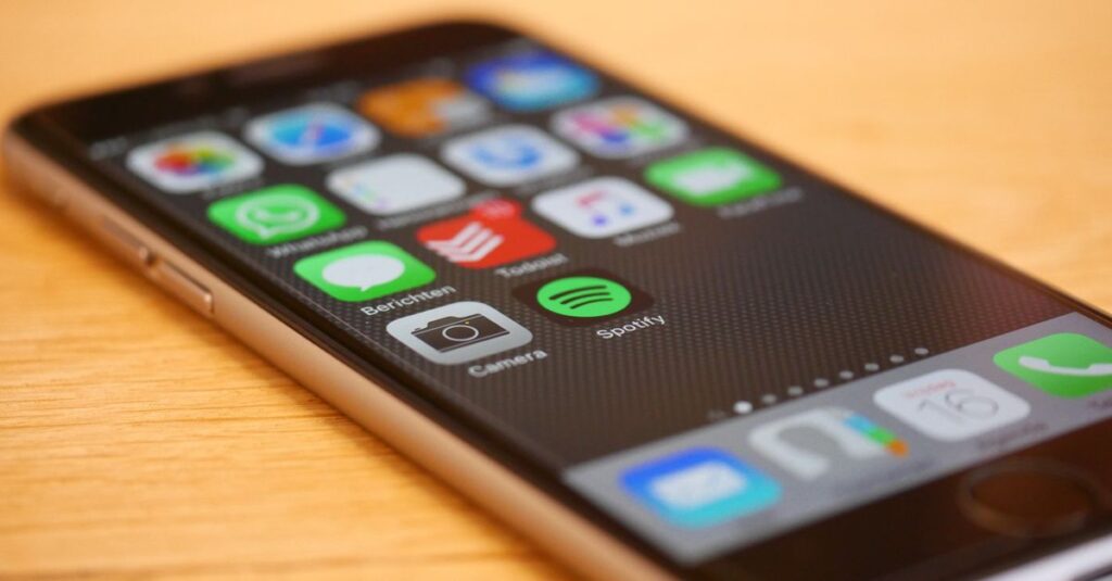 スマートフォンで家事分担アプリ（TimeTreeやOurHomeなど）を操作する夫婦の手元。