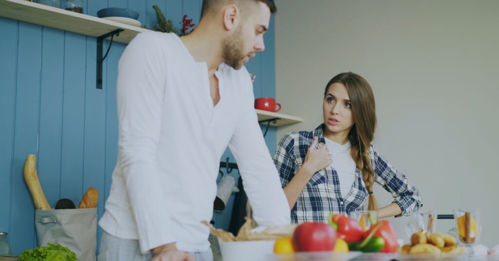 家事分担表を見ながら冷静に意見交換する夫婦のシーン。感情的にならず前向きに話し合う様子。
