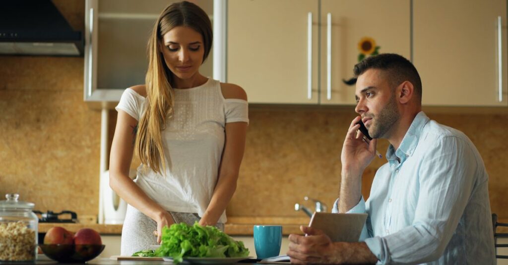 リビングでリラックスしながら家事分担の話をする夫婦。完璧を求めず柔軟に対応している様子。