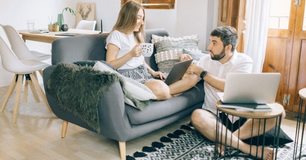 リビングでリラックスしながら家事分担の話をする夫婦。完璧を求めず柔軟に対応している様子。