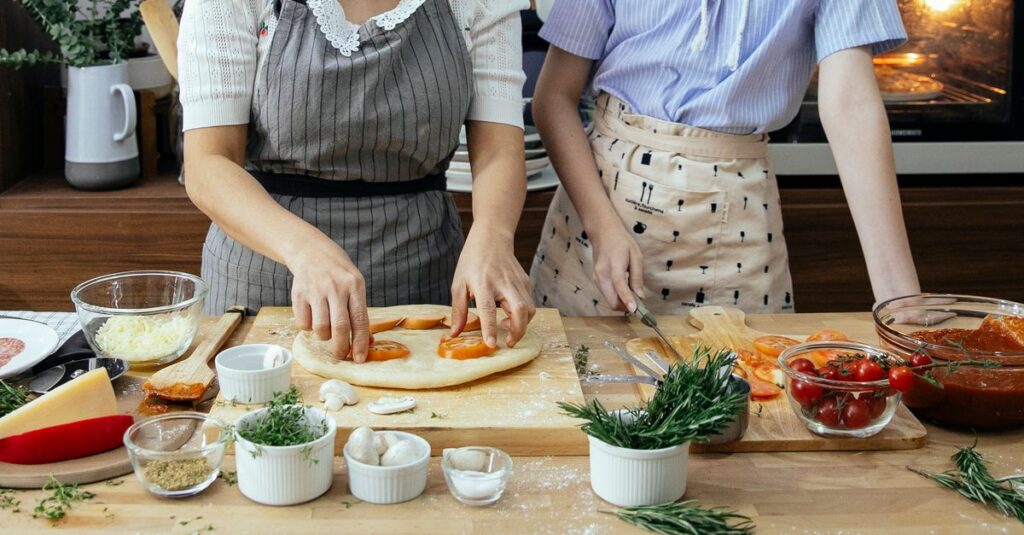 キッチンでミールキットの食材を調理する様子。色鮮やかな野菜や肉が並び、家族で料理を楽しむイメージ。