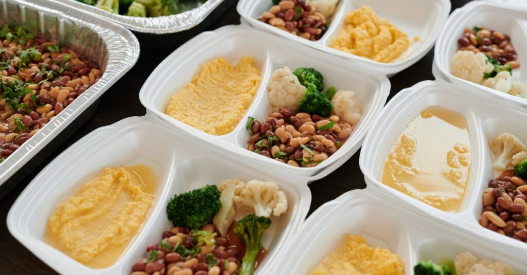 宅配食とミールキットを比較したイメージ。電子レンジで温める宅配弁当と調理中のミールキットの対比。
